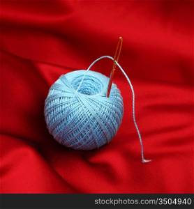 thread on red silk isolated close up