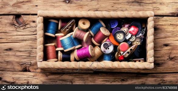 Thread spools and buttons. Wooden retro box, with thread spools and buttons. Sewing accessories.