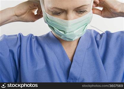 Threatre nurse adjusting mask