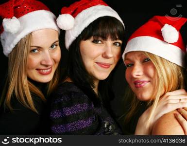 three 20-25 years women friends having fun on a christmas party