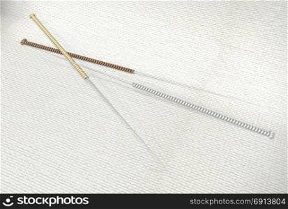 three acupuncture needles on fabric bckground