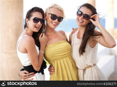 Three adorable women wearing sunglasses