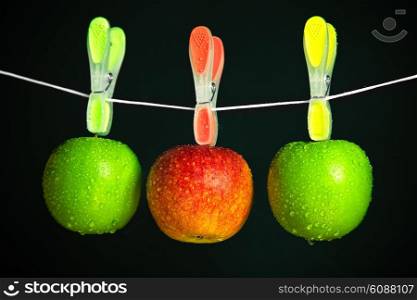 three apples in a row on black background