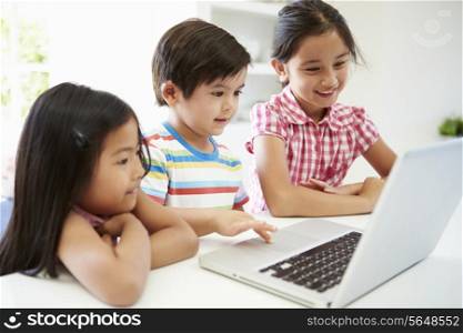 Three Asian Children Using Laptop At Home