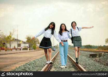 three asian teenager playing with happiness on railway track