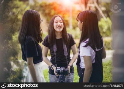 three asian teenager with dslr camera in hand pose as fashion model
