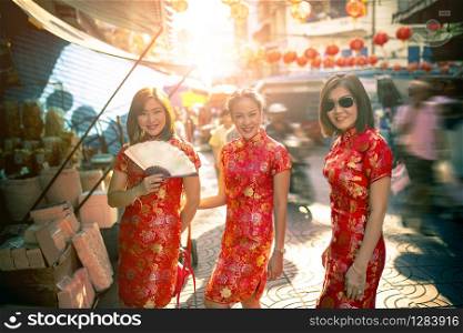 three asian woman wearing chinese tradition clothes toothy smiling face in yaowarat street china bangkok thailand