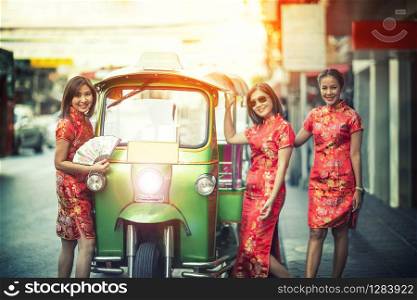 three asian woman wearing chinese traditon clothes standing beside tuktuk in yaowaratch road chinatown bangkok thailand