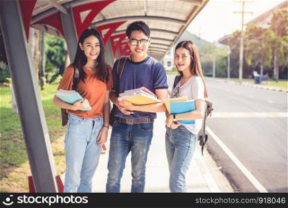 Three Asian young campus students enjoy tutoring and reading books together. Friendship and Education concept. Campus school and university theme. Happiness and funny of learning in college