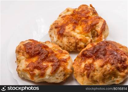 three baked flat breads with cheese on white background