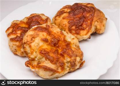 three baked flat breads with cheese on white background