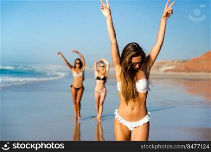 Three beautiful girls having fun on the beach