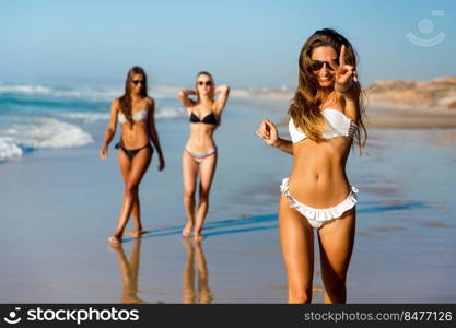 Three beautiful girls having fun on the beach