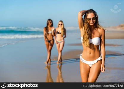 Three beautiful girls having fun on the beach