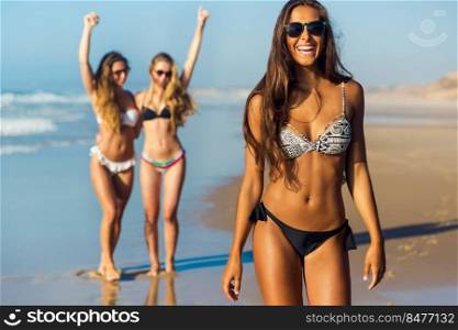 Three beautiful girls having fun on the beach