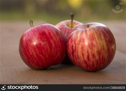 Three beautiful red apple on a wooden table