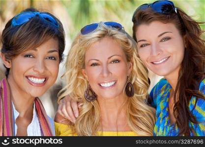 Three beautiful young women in their twenties laughing and having fun on vacation, shot in golden sunshine in a tropical resort location.