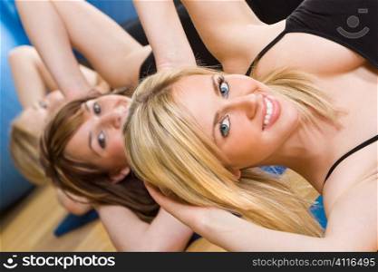 Three beautiful young women working out at the gym