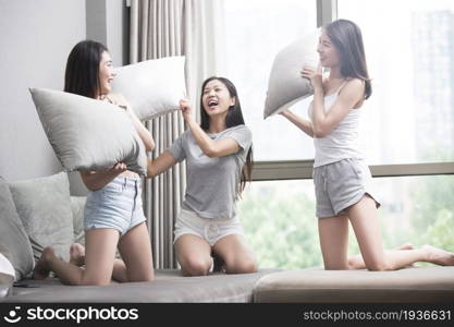 Three best friends having a pillow fight