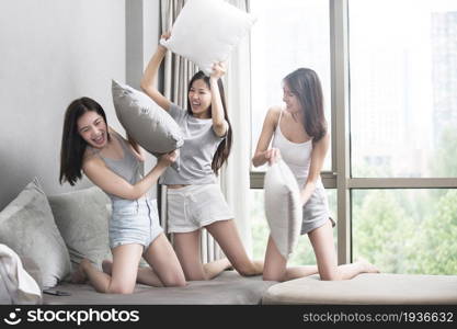 Three best friends having a pillow fight