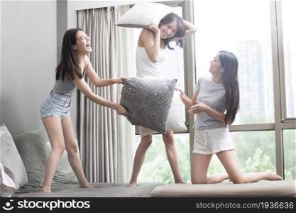 Three best friends having a pillow fight