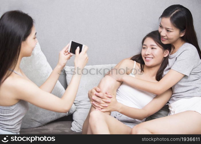 Three best friends taking photos on a mobile phone