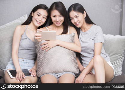 Three best friends taking selfies on a mobile phone