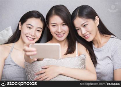 Three best friends taking selfies on a mobile phone