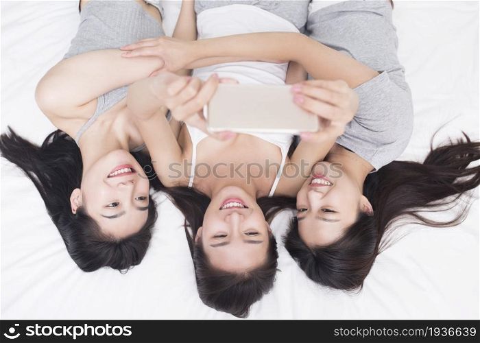 Three best friends taking selfies on a mobile phone