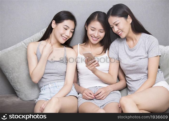 Three best friends using a mobile phone together