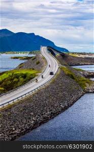 "Three bikers on motorcycles. Atlantic Ocean Road or the Atlantic Road (Atlanterhavsveien) been awarded the title as "Norwegian Construction of the Century"."