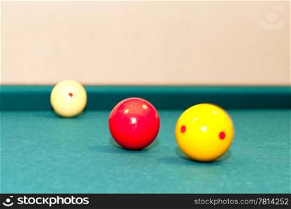 Three billiard balls, used for caroms or carambole on a table, with selective focus on the red ball