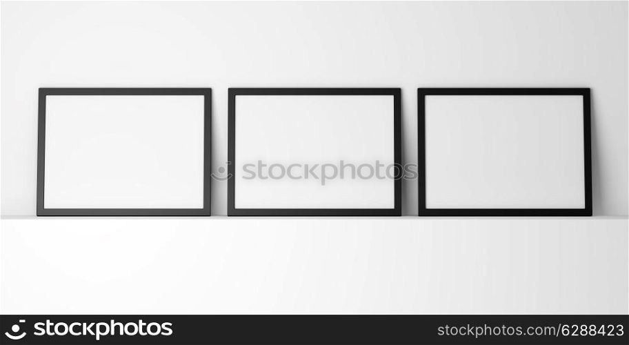 three blank black photo frames on white shelf