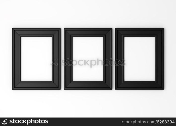 three blank black photo frames on white wall