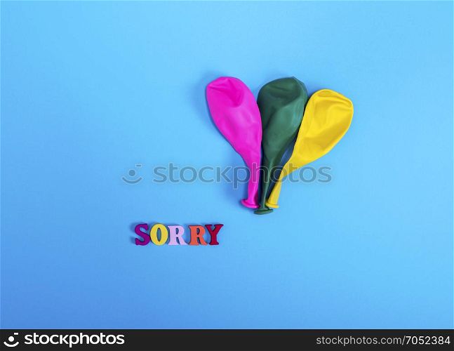three blow off balloons and the word sorry on a blue background