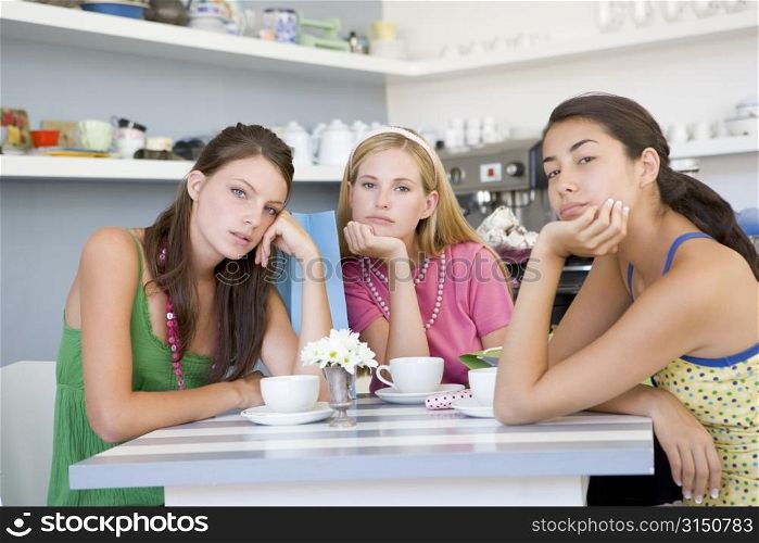Three bored young women sitting at a table