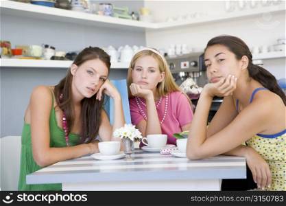 Three bored young women sitting at a table