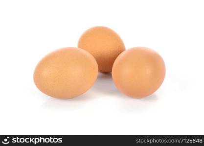 Three brown eggs in closeup and isolated on a white background.