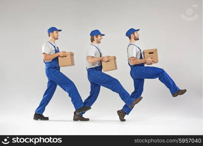 Three builders walking with boxes
