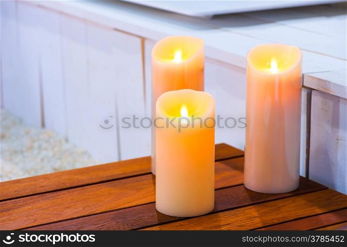 three burning candles on a wooden table