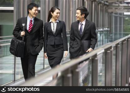 Three Business Colleagues Having Discussion Whilst Walking Outside Office
