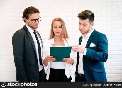 Three business people are looking at the summary report and consult together, Indoors Businessman and Businesswoman concept, Meeting and consulting concept