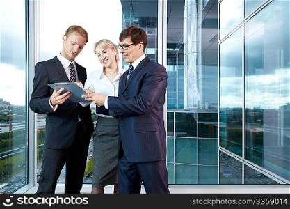 Three business people discussing a contract in the office