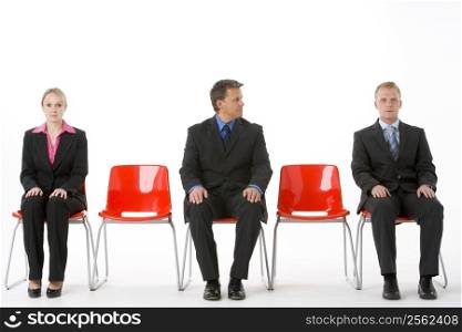 Three Business People Sitting On Red Plastic Seats