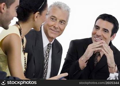 Three businessmen and a businesswoman at a meeting in a conference room