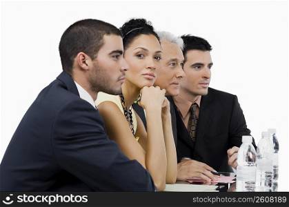 Three businessmen and a businesswoman at a meeting in a conference room