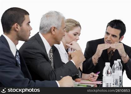 Three businessmen and a businesswoman at a meeting in a conference room