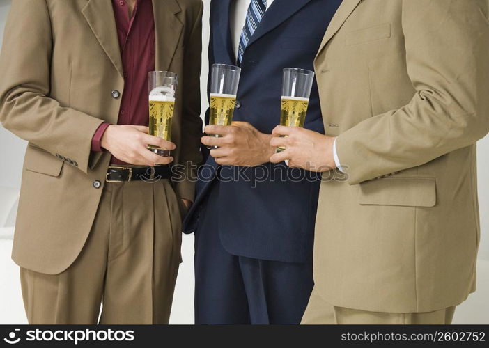 Three businessmen holding glasses of beer