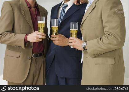 Three businessmen holding glasses of beer