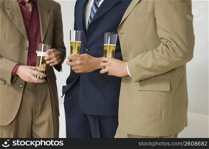 Three businessmen holding glasses of beer